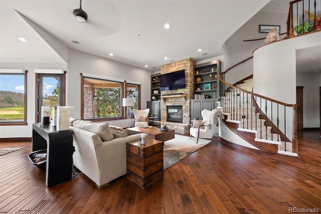 living room with a fireplace, hardwood / wood-style floors, stairs, recessed lighting, and baseboards