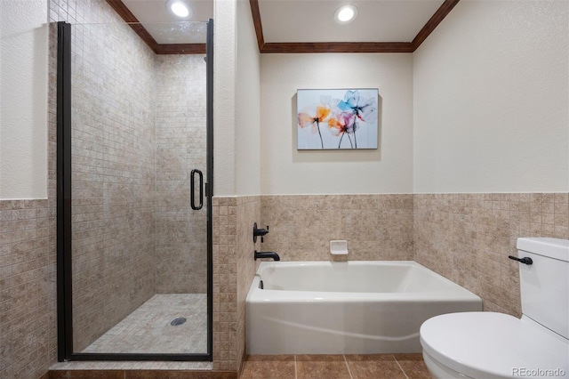 bathroom featuring crown molding, a stall shower, a bath, toilet, and tile walls
