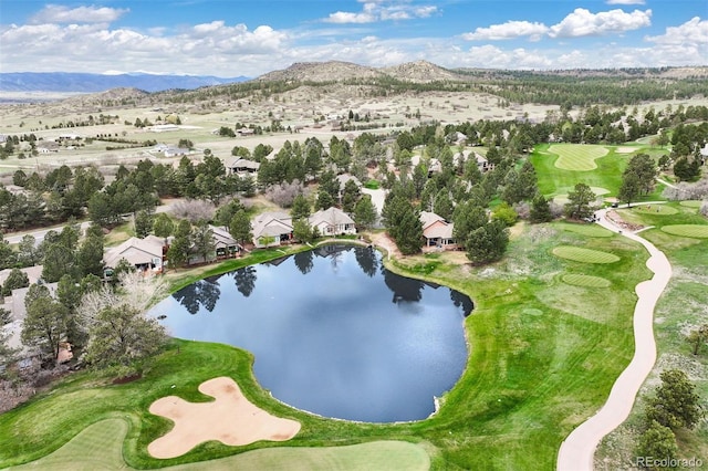 view of property location featuring a water and mountain view, a local golf course, and nearby suburban area