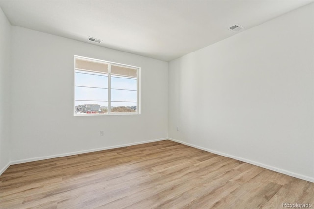 unfurnished room with visible vents, baseboards, and light wood-style floors