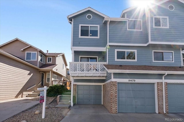 multi unit property featuring stone siding, concrete driveway, and a garage