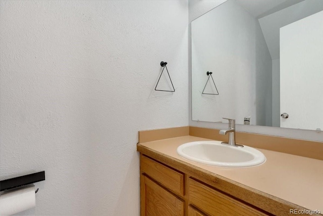 bathroom featuring vanity and a textured wall