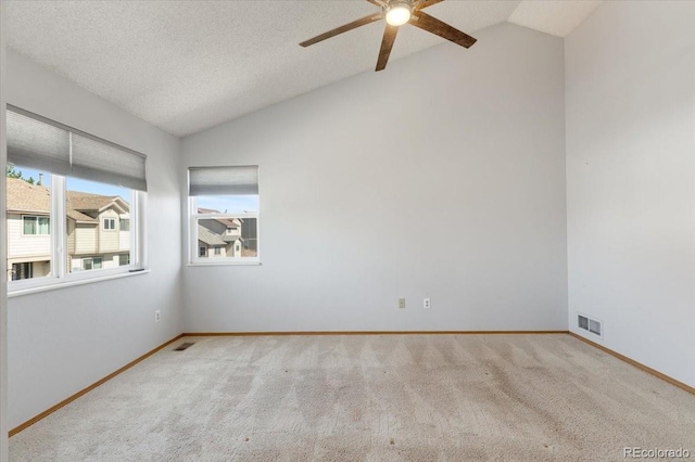 carpeted spare room featuring a ceiling fan, baseboards, visible vents, lofted ceiling, and a textured ceiling