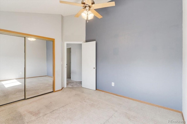 unfurnished bedroom with a closet, carpet floors, high vaulted ceiling, and ceiling fan