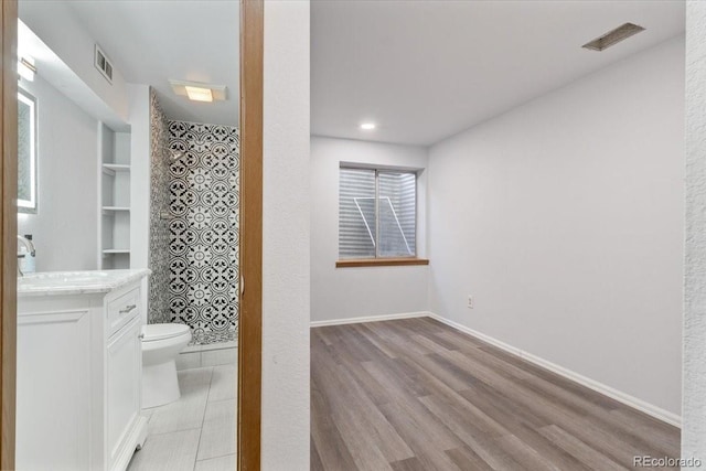 full bathroom featuring visible vents, a walk in shower, baseboards, toilet, and wood finished floors