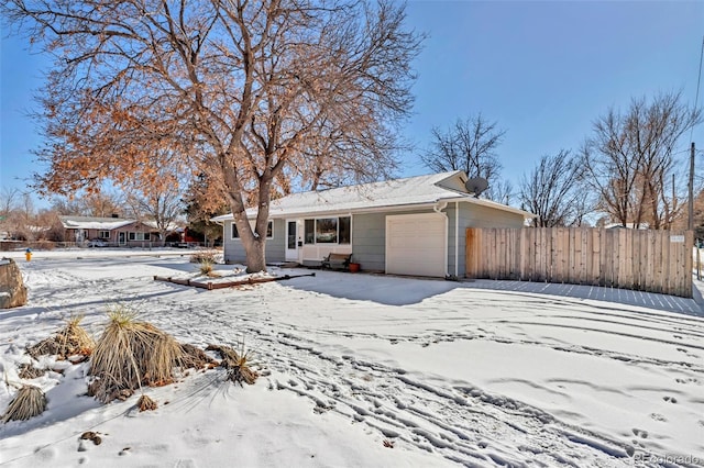 snow covered house featuring a garage