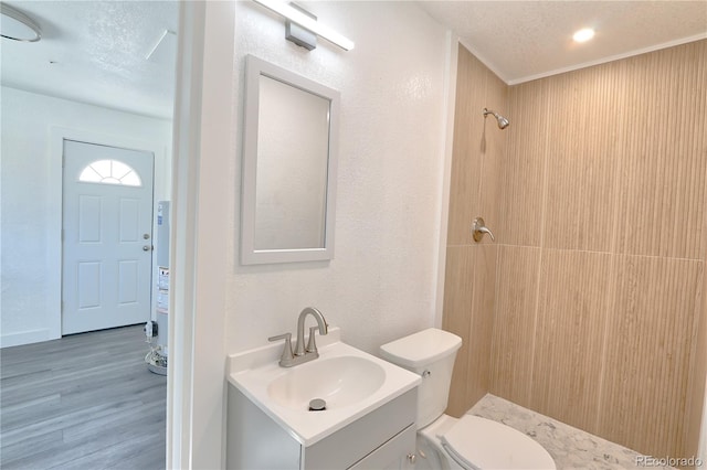 bathroom with vanity, a shower, hardwood / wood-style flooring, toilet, and a textured ceiling