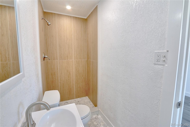 bathroom featuring a textured ceiling, sink, toilet, and a shower