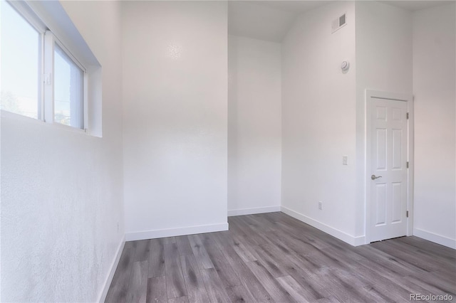 unfurnished room with wood-type flooring and vaulted ceiling