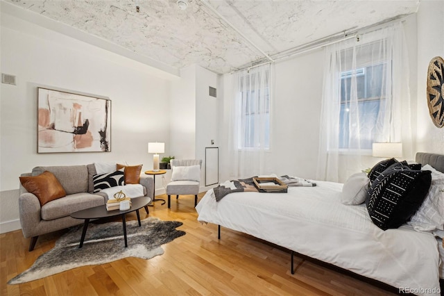 bedroom with visible vents and wood finished floors