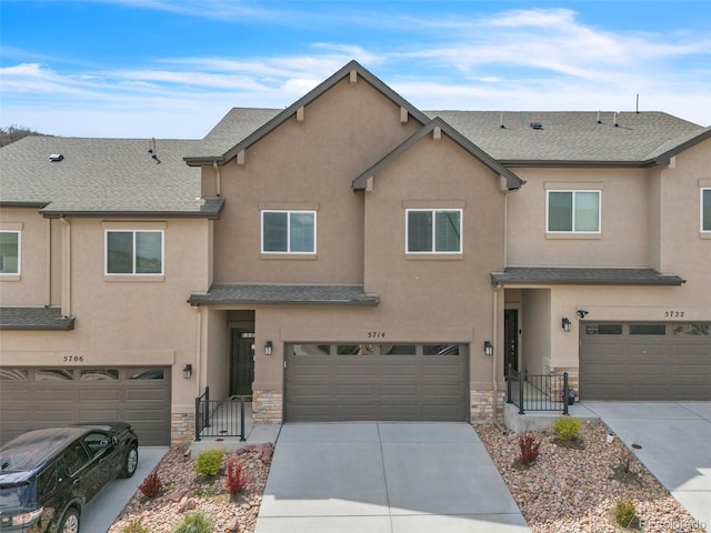5714 Villa Lorenzo Dr, Colorado Springs, CO 80919 - townhome / multi-family property with stone siding, stucco siding, an attached garage, and concrete driveway