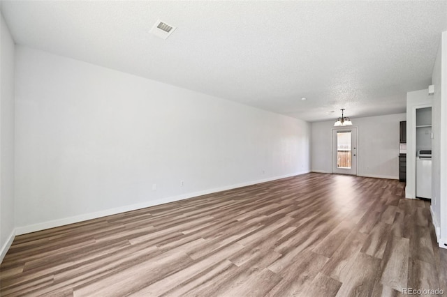 920 44th Avenue Ct Unit 30, Greeley, CO 80634 - unfurnished living room featuring wood finished floors, a chandelier, and a textured ceiling