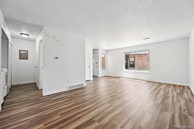 920 44th Avenue Ct Unit 30, Greeley, CO 80634 - unfurnished living room featuring a textured ceiling, wood finished floors, and washing machine and dryer