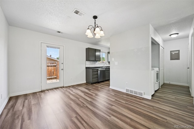 920 44th Avenue Ct Unit 30, Greeley, CO 80634 - unfurnished living room with washer and clothes dryer, dark wood-style floors, a textured ceiling, and a chandelier