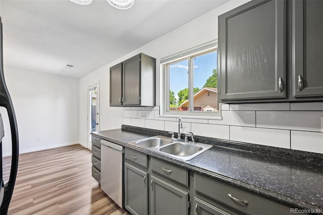 920 44th Avenue Ct Unit 30, Greeley, CO 80634 - kitchen with white dishwasher, light wood-style floors, dark countertops, gray cabinetry, and a textured ceiling
