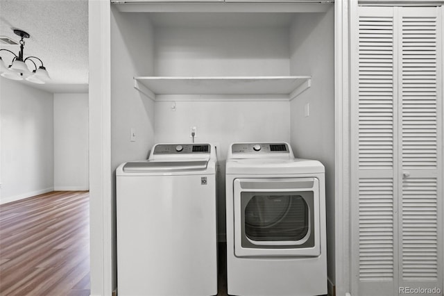 920 44th Avenue Ct Unit 30, Greeley, CO 80634 - washroom with washing machine and clothes dryer, wood finished floors, a textured ceiling, and a chandelier