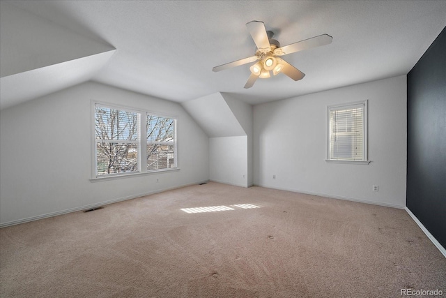 additional living space featuring light colored carpet, vaulted ceiling, and ceiling fan