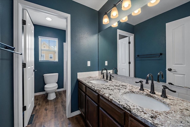 bathroom with hardwood / wood-style flooring, vanity, and toilet