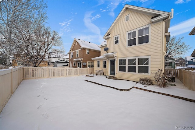 view of snow covered rear of property