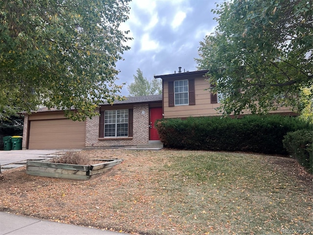 tri-level home featuring a garage and a front yard