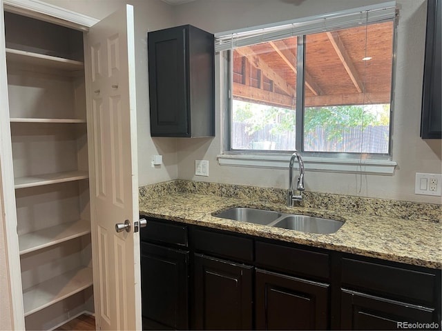 kitchen featuring light stone countertops and sink