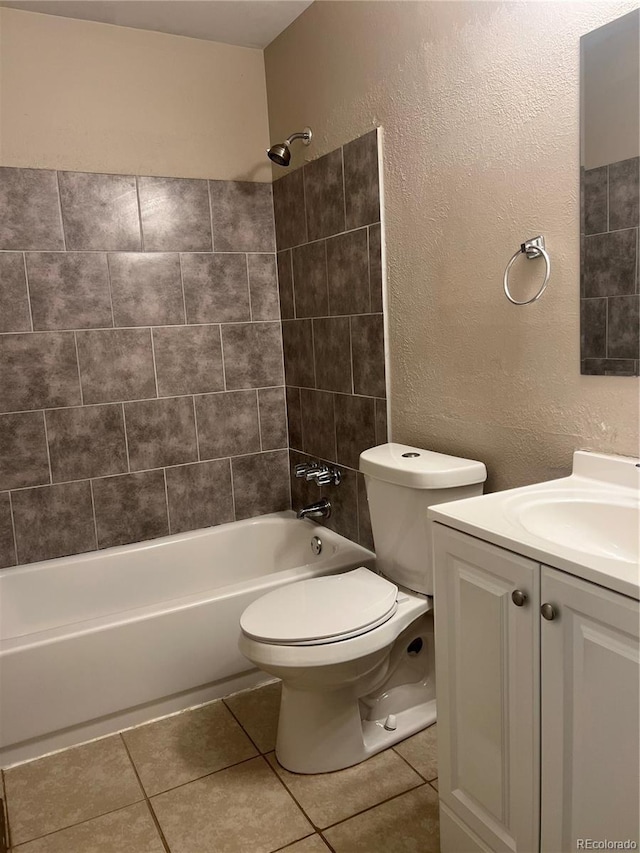 full bathroom with toilet, vanity, tiled shower / bath, and tile patterned floors