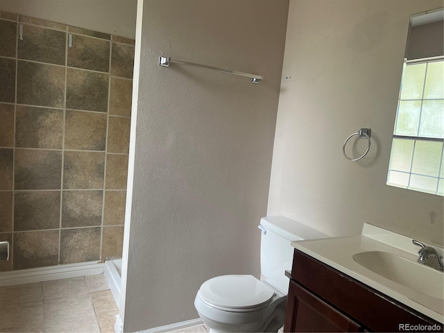 bathroom featuring tile patterned floors, vanity, toilet, and a tile shower