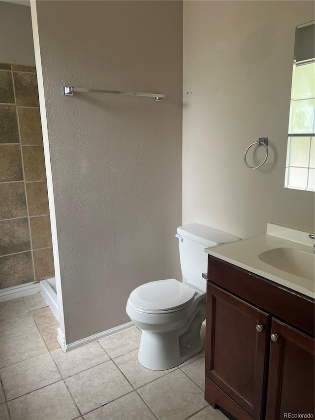 bathroom with vanity, tile patterned floors, toilet, and a shower