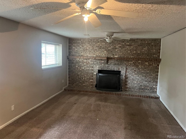 unfurnished living room with a fireplace, ceiling fan, a textured ceiling, and dark carpet