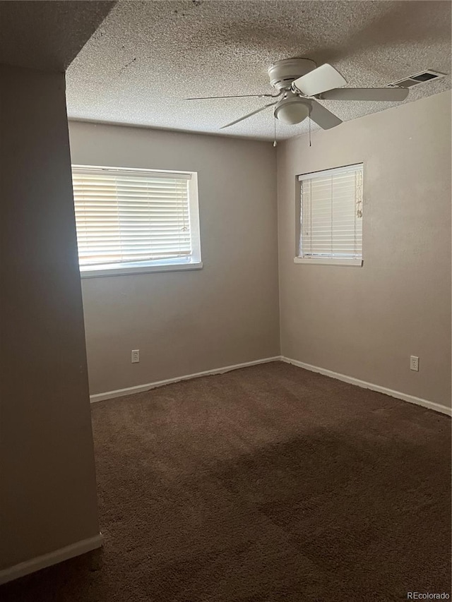 carpeted spare room with a textured ceiling and ceiling fan