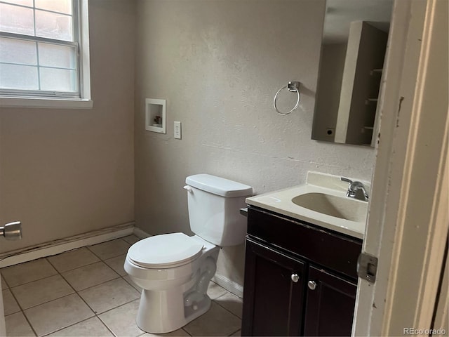 bathroom with toilet, vanity, and tile patterned flooring