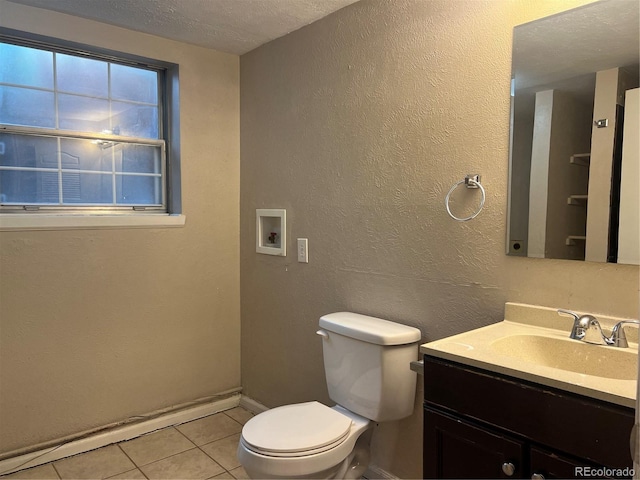 bathroom with toilet, vanity, a textured ceiling, and tile patterned floors