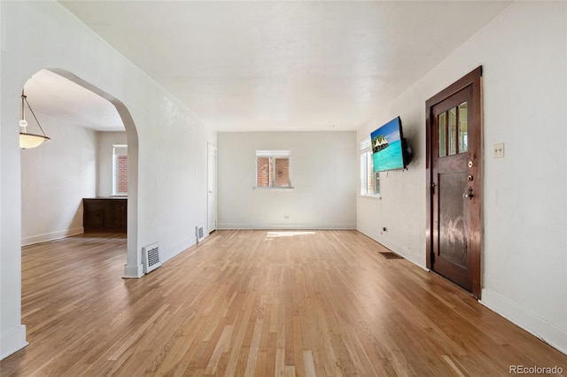 521 Harrison St, Denver, CO 80206 - unfurnished living room featuring arched walkways and light wood-style flooring