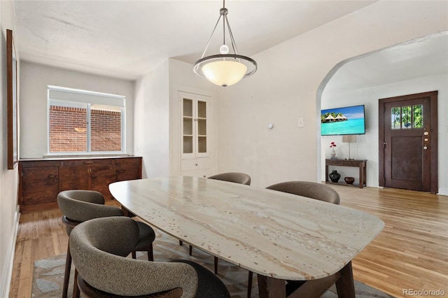 521 Harrison St, Denver, CO 80206 - dining area with arched walkways and light wood-style flooring