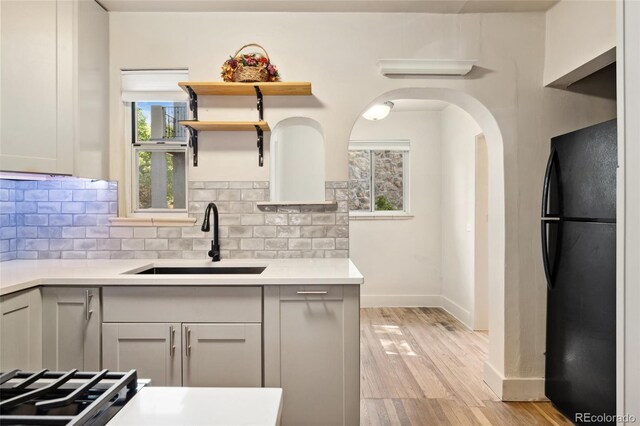521 Harrison St, Denver, CO 80206 - kitchen with freestanding refrigerator, decorative backsplash, light wood-type flooring, light countertops, and open shelves