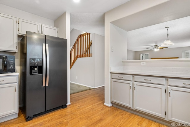 kitchen featuring pendant lighting, stainless steel fridge with ice dispenser, white cabinets, and light wood-type flooring