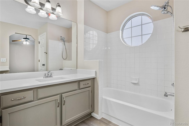 bathroom with ceiling fan, vanity, bathtub / shower combination, and hardwood / wood-style floors