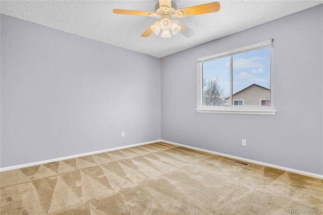 carpeted empty room with ceiling fan and a textured ceiling