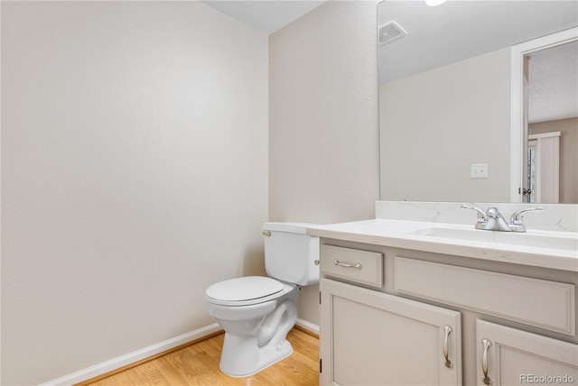 bathroom featuring vanity, hardwood / wood-style flooring, and toilet