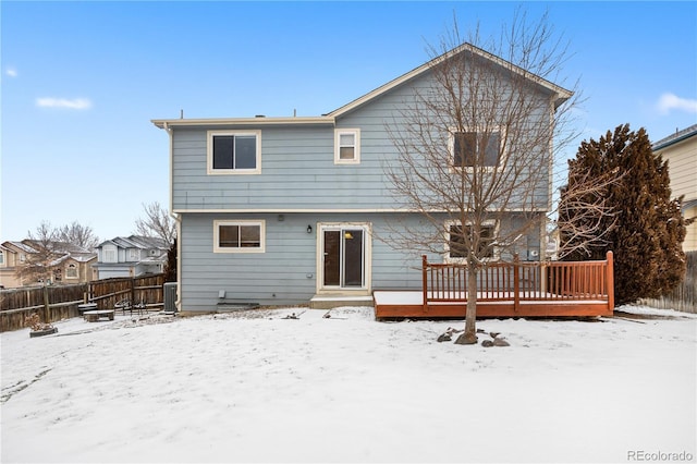 snow covered house featuring a deck