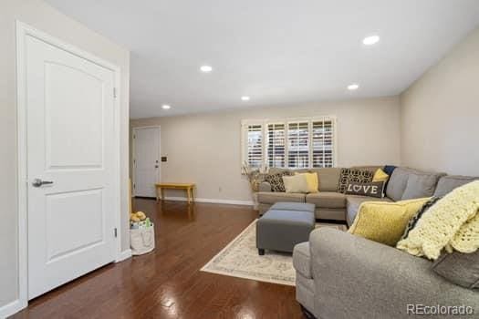 living area with dark wood-style floors, baseboards, and recessed lighting