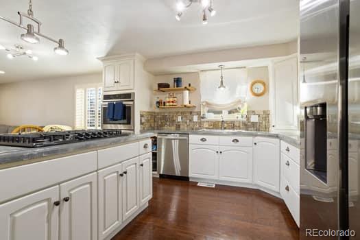 kitchen with white cabinetry, appliances with stainless steel finishes, decorative backsplash, open shelves, and dark wood finished floors