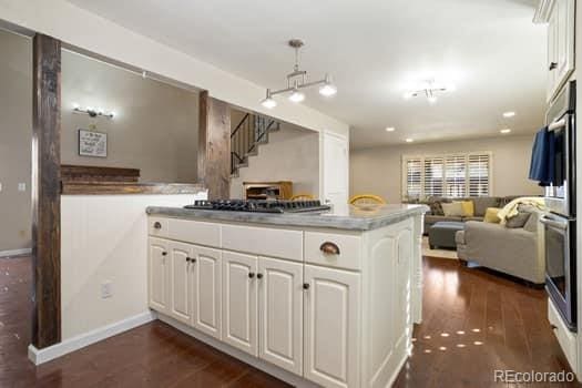 kitchen featuring dark wood-style floors, open floor plan, white cabinetry, and baseboards