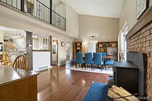 unfurnished living room with a chandelier, a high ceiling, wood finished floors, and visible vents