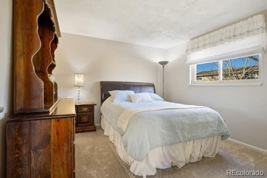 bedroom with light carpet and baseboards