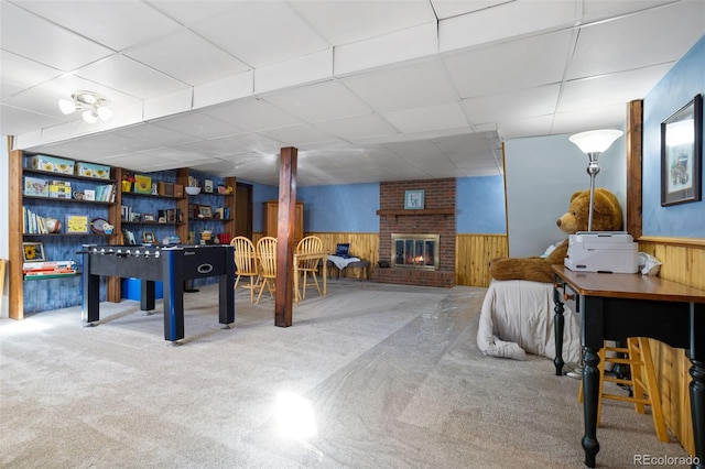 playroom featuring a paneled ceiling, wainscoting, and wood walls