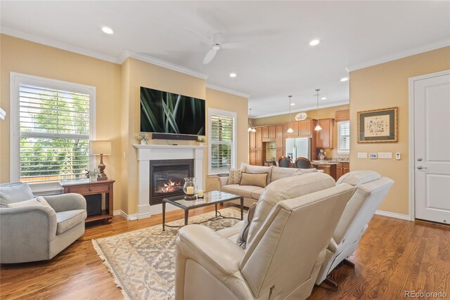 10182 Bristleridge St, Parker, CO 80134 - living room with a glass covered fireplace, ceiling fan, baseboards, healthy amount of natural light, and ornamental molding