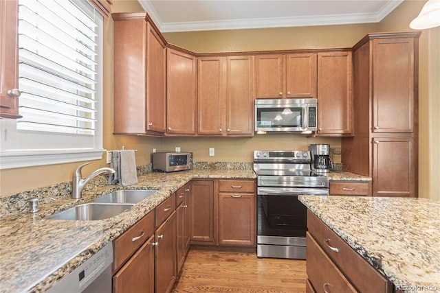 10182 Bristleridge St, Parker, CO 80134 - kitchen with stainless steel appliances, a sink, light wood-type flooring, brown cabinetry, and light stone counters