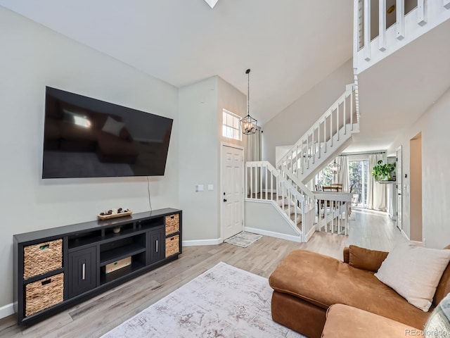 living room featuring a chandelier and light wood-type flooring