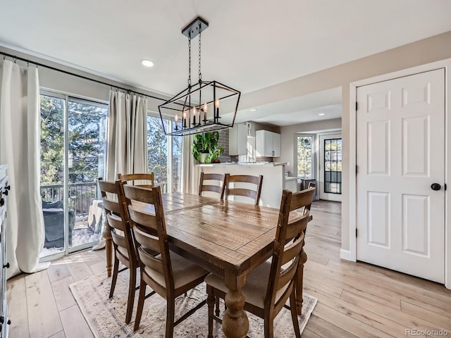 dining space featuring a notable chandelier and light wood-type flooring